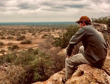 Couple enjoying a peaceful sunset, seated and gazing at the horizon at the ranch.